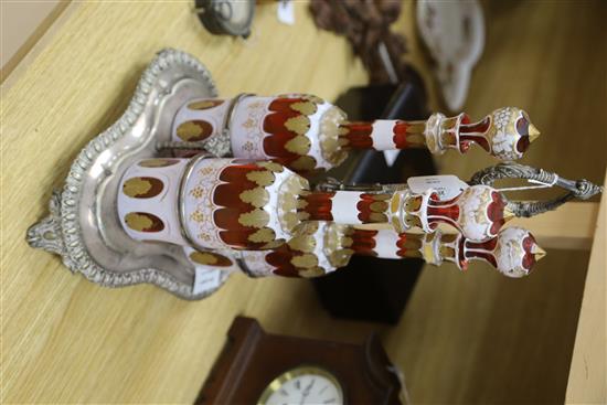 A plated three bottle tantalus, the decanters overlaid glass with gilt decoration, height 37cm